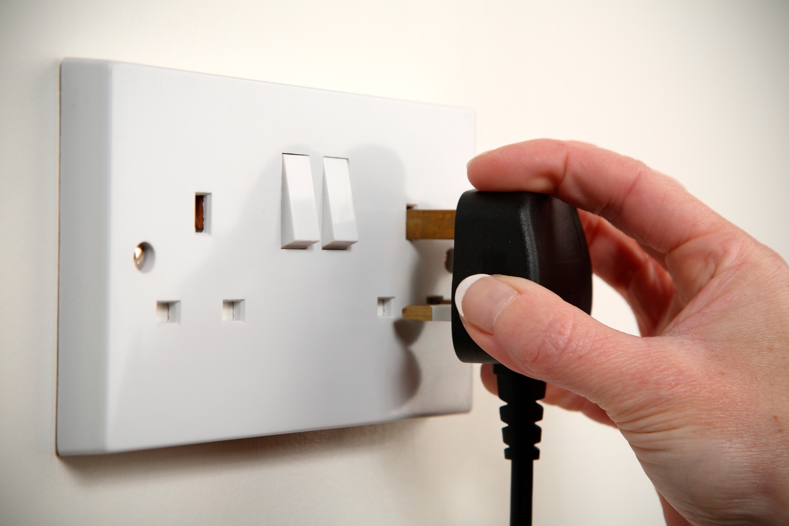 Someone inserting a black plug in to a innocent looking socket